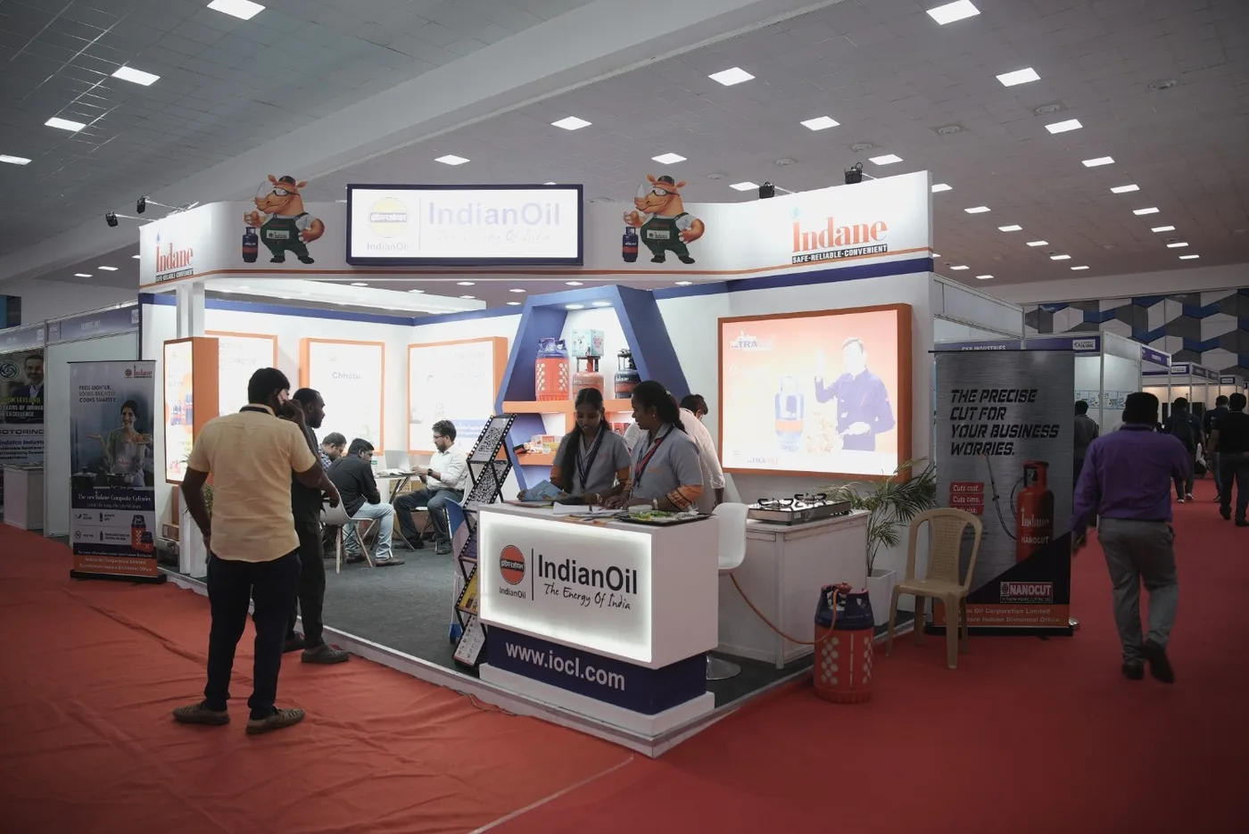 Visitors and exhibitors on the INDTEC EXPO floor, with an industrial stand and product displays